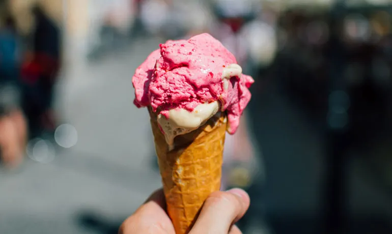 55 ways to save money - view of hand holding ice cream cone