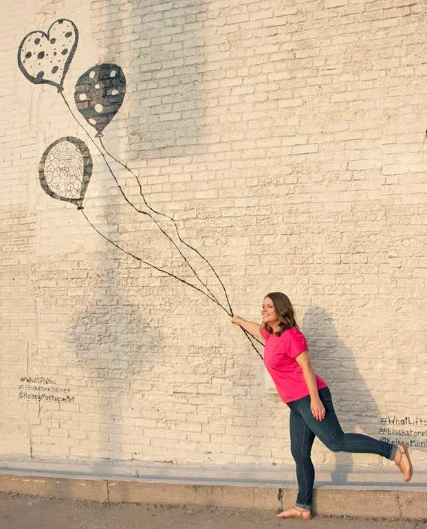 holding balloons at the Kelsey Montague mural in Omaha