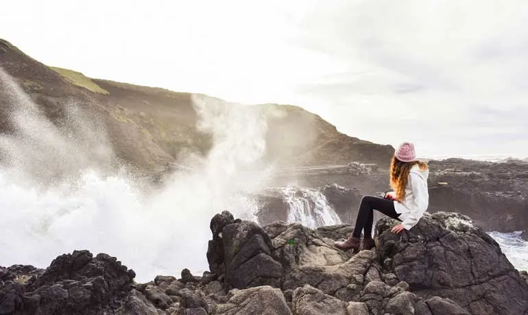 girl sitting on cliffs at Yachats, Oregon