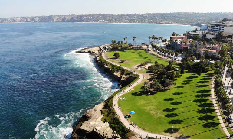 California coastline from above with picturesque palm trees and blue water