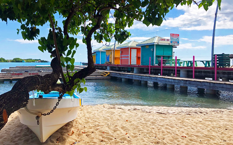 belize boat near water with colorful huts