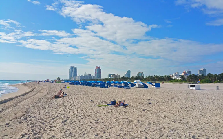 beach with sand, blue sky and city in background, best beaches in Miami for families 