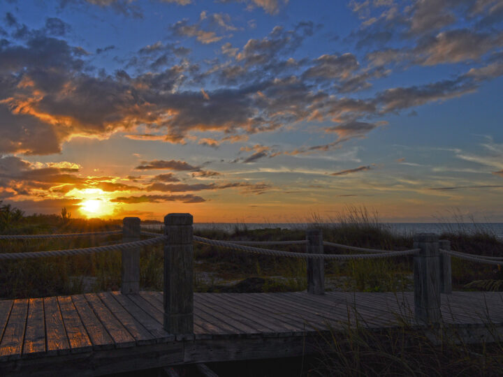 where to watch the sunset turks and caicos photo of sun setting in sky with wooden bridge and coast with blue orange sky