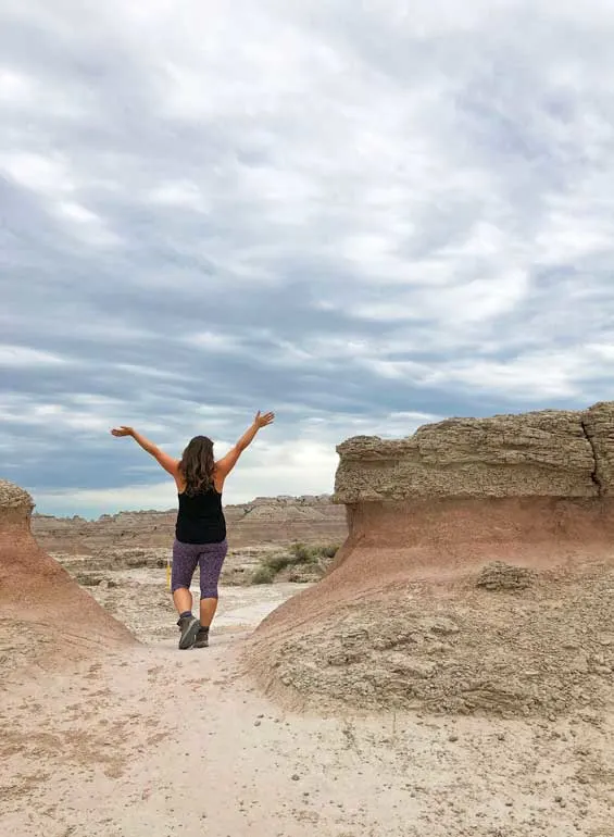 woman standing between 2 rock formations on a cloudy day