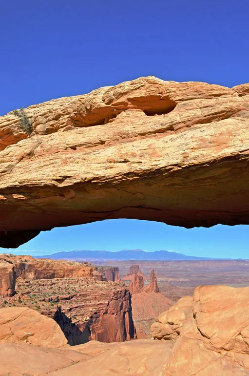 mesa arch canyonlands best national parks to visit in April looking through arch to canyon in background