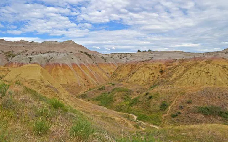 visit-south-dakota-yellow hills on cloudy day