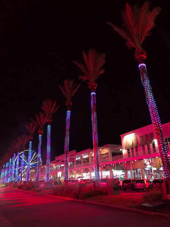 the wharf at orange beach light show with palm trees and buildings red