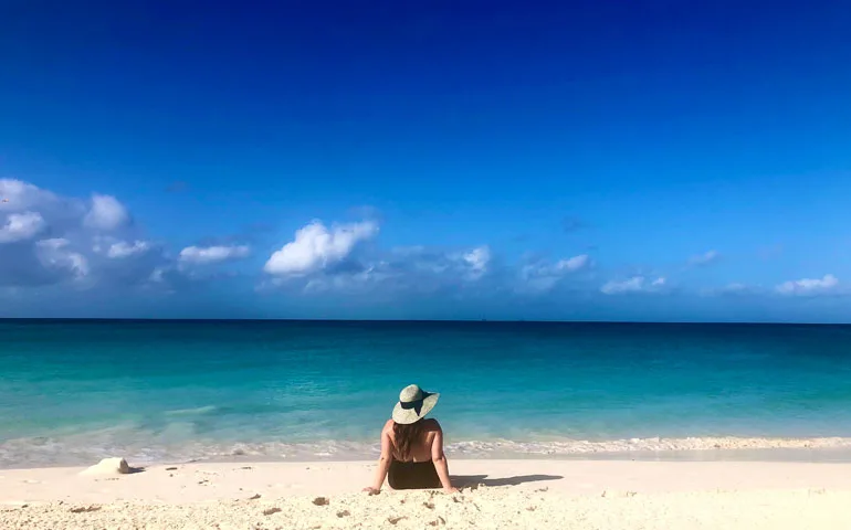 woman sitting on divi beach, aruba