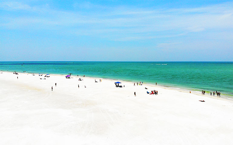 best family vacation spots in florida white sand beach teal water blue sky arial view