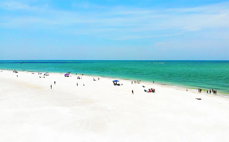 best family vacation spots in florida white sand beach teal water blue sky arial view