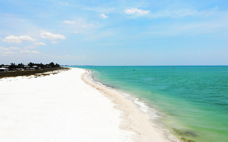 white sandy beach with green water