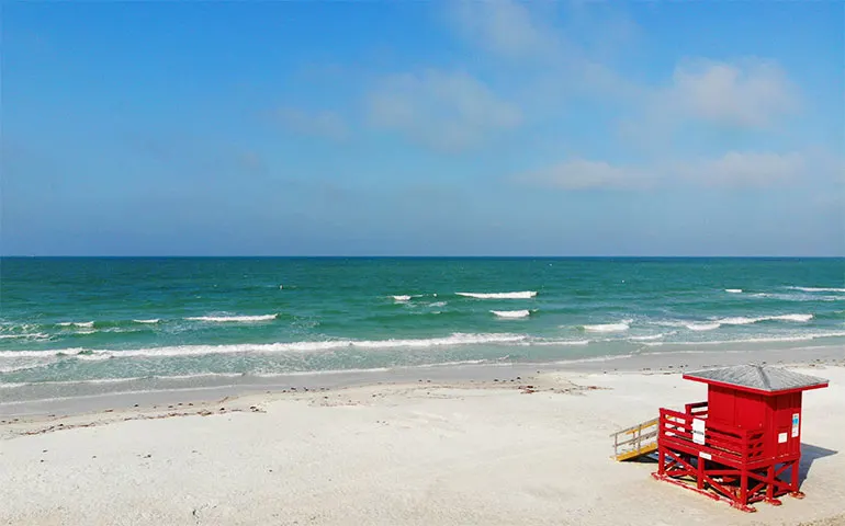 vacation in florida white sand beach teal water red lifeguard stand