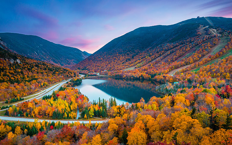 best fall vacations in the us - fall foliage with mountains and lake at sunset