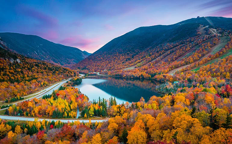 best fall vacations in the us - fall foliage with mountains and lake at sunset
