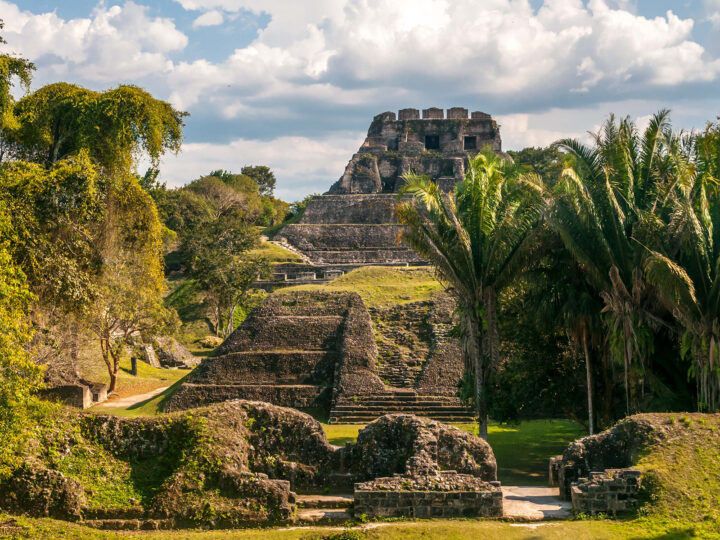 xunantunich mayan ruins photo of palm trees and ancient ruins on cloudy day