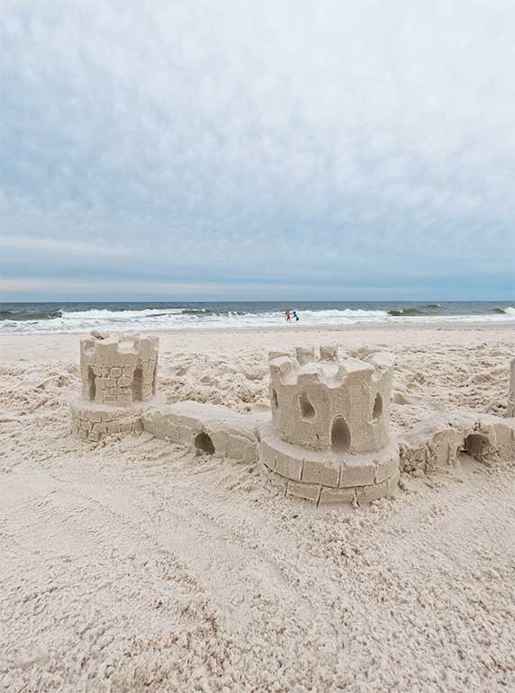 orange beach activities - building sand castles on the beach with blue sky