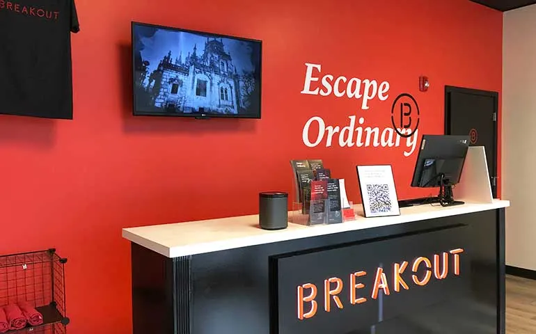 entrance of breakout escape room orange beach, including red wall, front desk