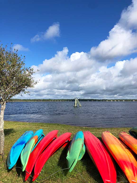 top things to do in orange beach include kayaking on lake Shelby photo shows kayaks in foreground with lake and blue sky