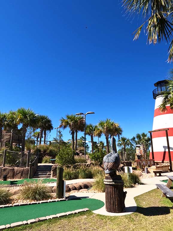 mini golf course in orange beach with stripe lighthouse in background