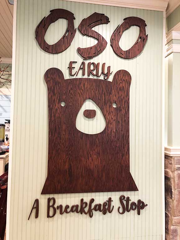 oso early breakfast sign with a carved bear