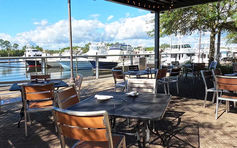 restaurant table overlooking the water with boats in background