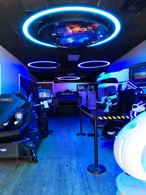 vr game room with black lights and sit-on toys