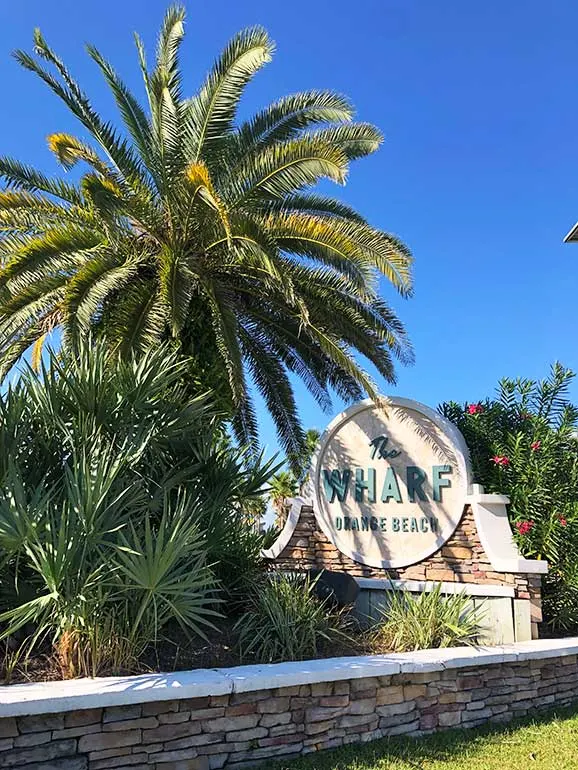 the wharf orange beach sign with palm tree and blue sky
