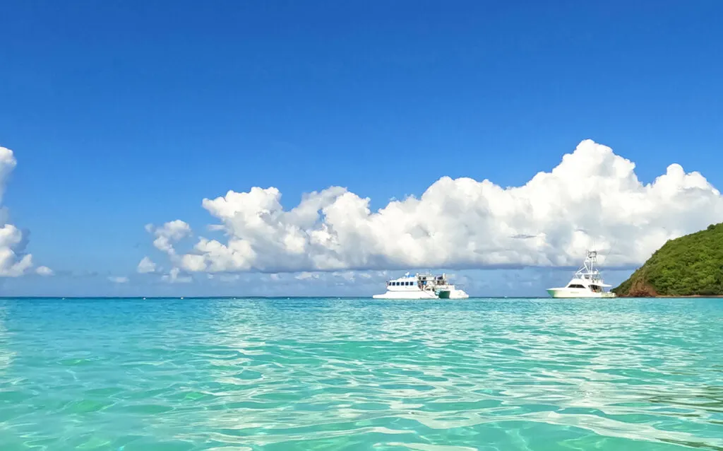 catamaran and yacht in teal water