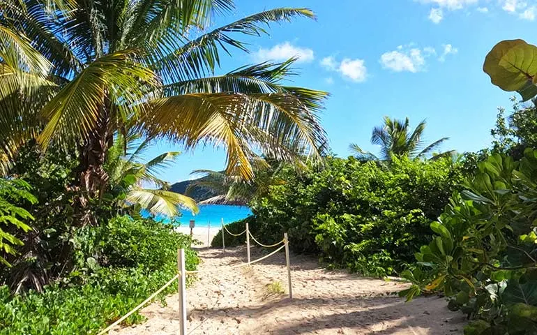 entrance to flamenco beach sandy pathway towards blue ocean