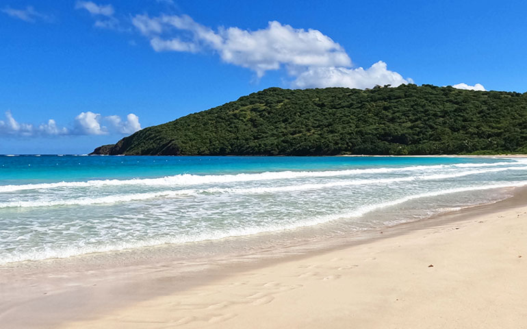 beautiful caribbean water and hillside backdrop with white waves at Flamenco beach Puerto rico