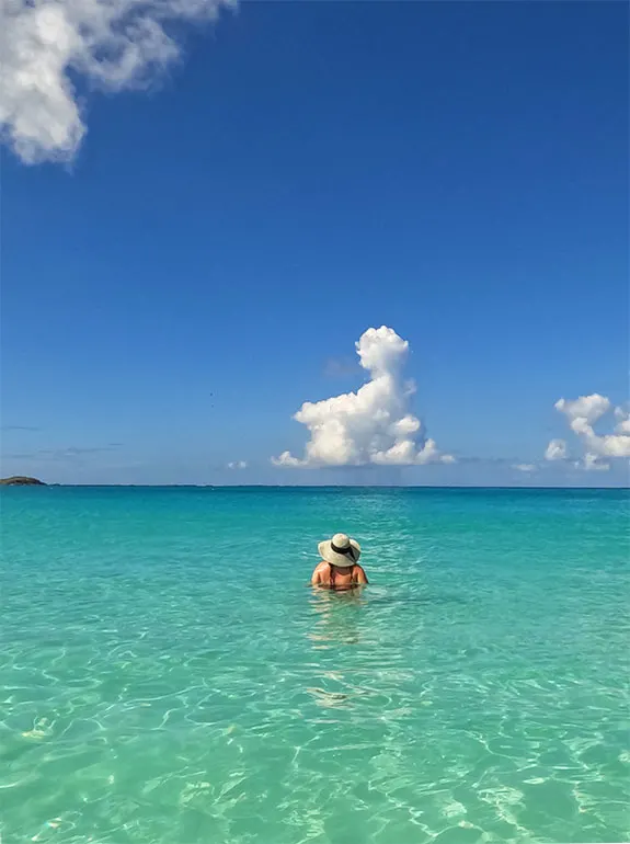 woman swimming in the Caribbean Sea wearing a sun hat