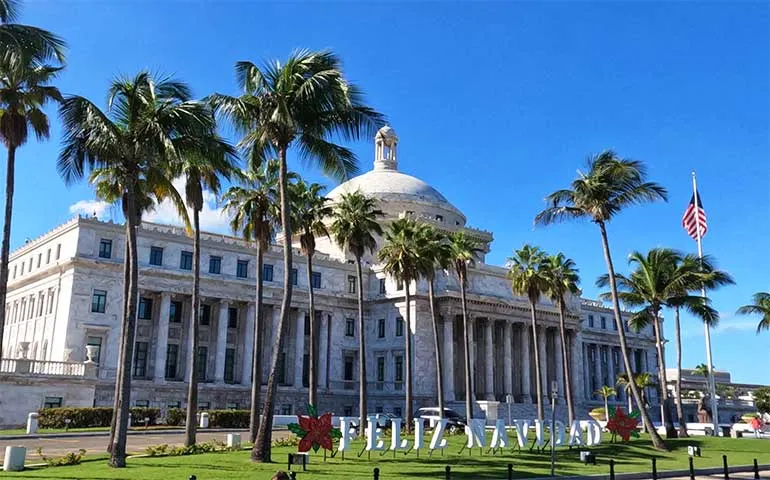 large building with palm trees in front