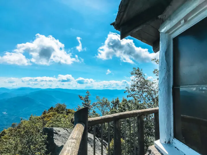 mountain honeymoon destinations usa view of smoky mountains with cabin window and railing in forefront