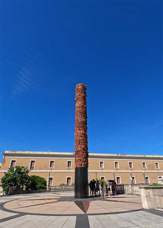 totem pole in San Juan pr built on concrete plaza building in background