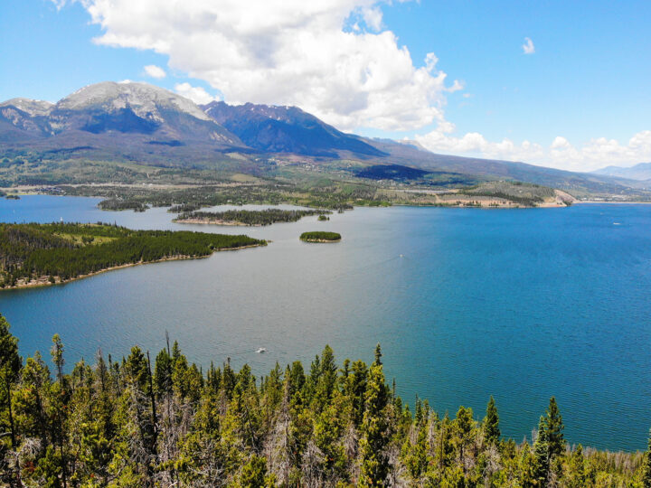 blue lake against Rocky Mountain peaks on a sunny day