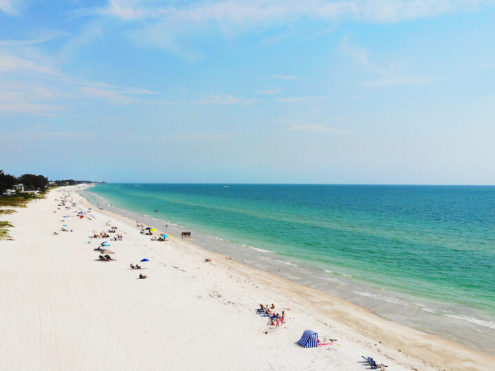 white sandy beach from above with teal water