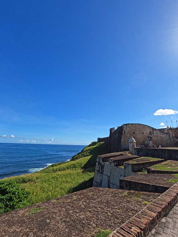 places to visit in old San Juan picture of a brick fort along the coast on a sunny day
