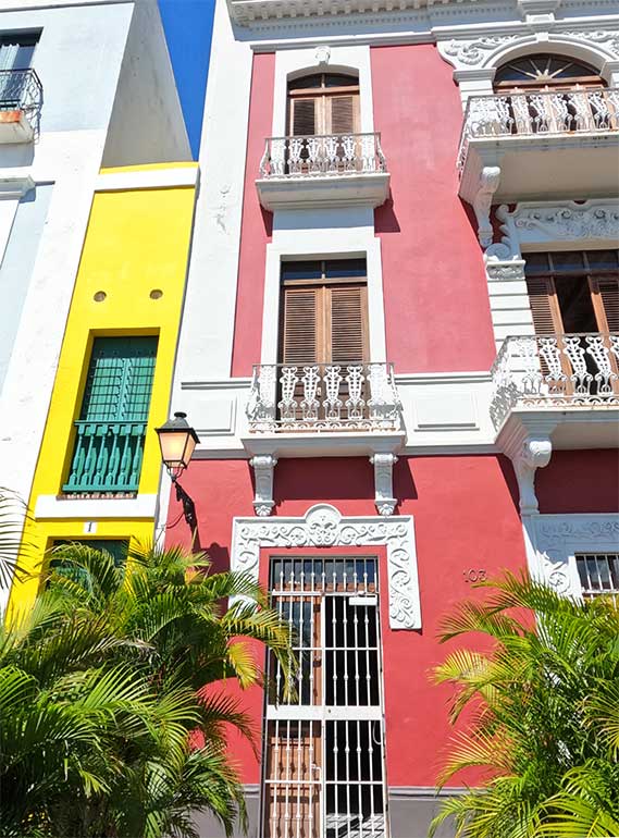 narrow houses old San Juan bright yellow, red with palm trees