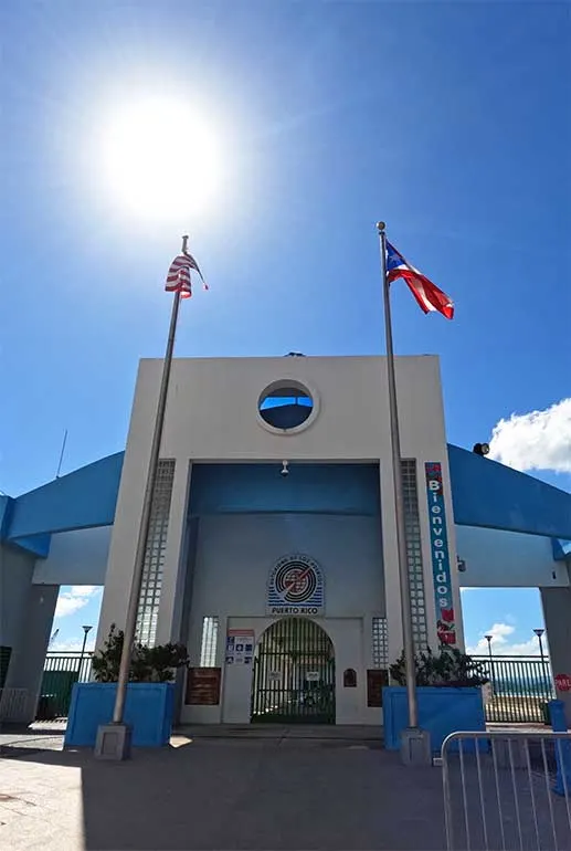 front of San Juan port entrance with US and PR flags on a sunny day