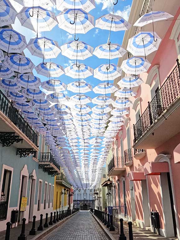 umbrella street old San Juan with colorful buildings and umbrellas hung from strings above