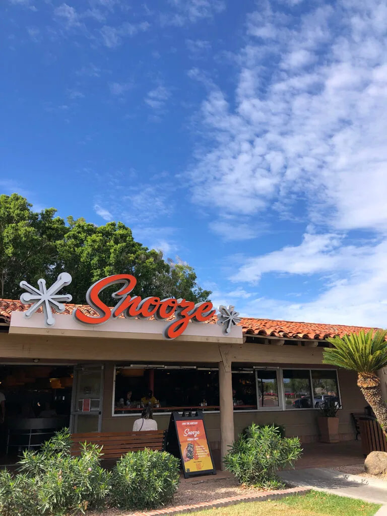 snooze restaurant storefront with blue sky and snooze signage