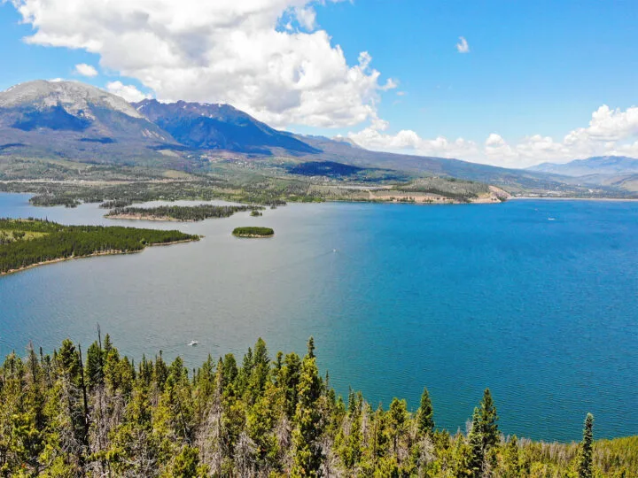 Things to do in Dillon CO, pic of blue lake against Rocky Mountain peaks on a sunny day