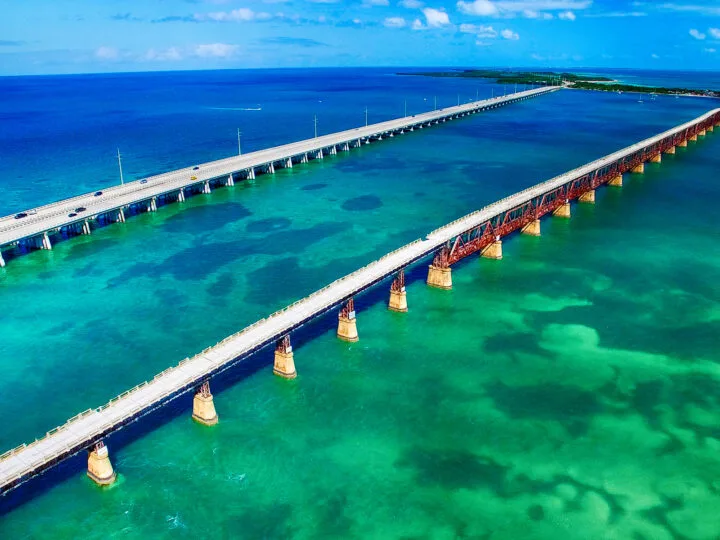 miami to key west road trip picture of 2 bridges over turquoise green water leading to island in distance