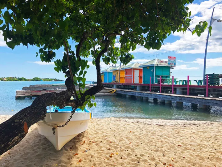 boat on the beach in Belize with colorful buildings