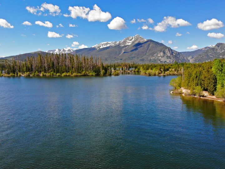 colorado itinerary road trip picture of large lake with mountains and trees on partly cloudy day