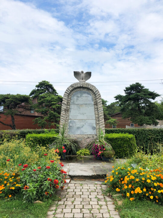 cement statue in flower garden on sunny day