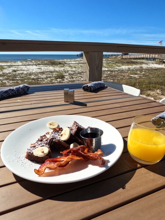 best orange beach restaurants plate of breakfast food on table with beach in backgroundq
