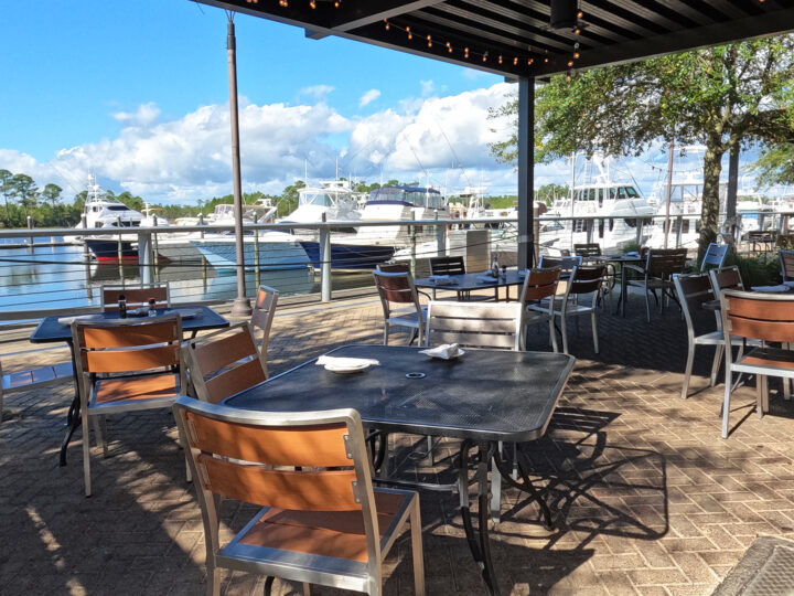 best orange beach restaurants on the water photo of tables outdoor with boats in background