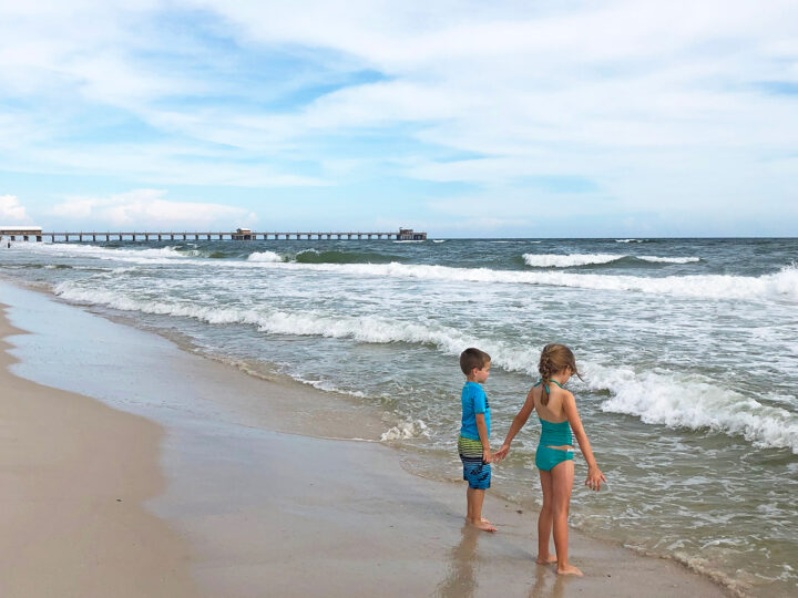things to do in gulf shores with kids picture of 2 kid on beach white waves on partly sunny day