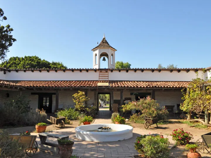 things to do in old town San Diego museum with Spanish architecture, plants and brick pathways in historic setting